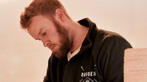 Medewerker van BurgerArt die verse burgeringrediënten voorbereidt in de foodtruck.